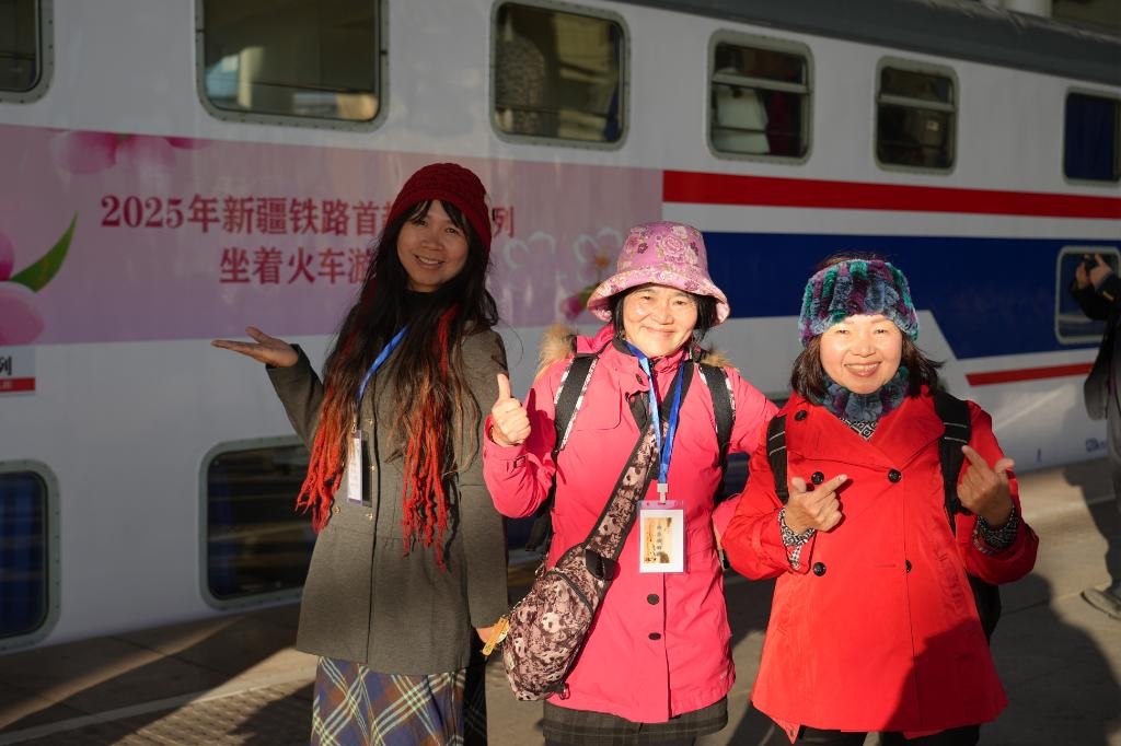 图为3月27日，游客在Y950次旅游专列旁合影。这是新疆铁路部门今年开行的首趟“银发旅游专列”。（国铁乌鲁木齐局集团公司供图）