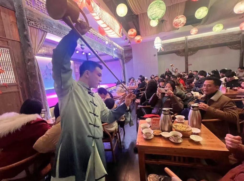 1月31日，游客在四川成都的茶馆体验盖碗茶表演互动。新华社发